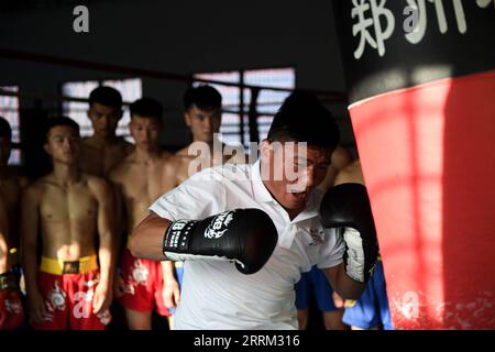 220929 -- ZHENGZHOU, 29. September 2022 -- Li Yinggang demonstriert für Schüler während einer kostenlosen Kampfklasse an der Shaolin Tagou Martial Arts School in Songshan, Provinz Henan in Zentralchina, 6. Juli 2022. Der 25-jährige Li Yinggang ist Coach an der Shaolin Tagou Martial Arts School in Songshan, der zentralchinesischen Provinz Henan. Im Alter von 9 Jahren begann er mit dem Kampfsport und wechselte drei Jahre später in den freien Kampf. Seit seinem 16. Lebensjahr nimmt Li an den professionellen Freikampfwettbewerben Teil und gewinnt mehrmals die Titel nationaler und internationaler Veranstaltungen, darunter zwei goldene Stockfoto