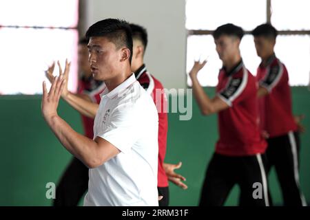 220929 -- ZHENGZHOU, 29. September 2022 -- Li Yinggang Front unterrichtet Schüler während eines Kampfkunstkurses an der Shaolin Tagou Martial Arts School in Songshan, Provinz Henan in Zentralchina, 6. Juli 2022. Der 25-jährige Li Yinggang ist Coach an der Shaolin Tagou Martial Arts School in Songshan, der zentralchinesischen Provinz Henan. Im Alter von 9 Jahren begann er mit dem Kampfsport und wechselte drei Jahre später in den freien Kampf. Seit seinem 16. Lebensjahr nimmt Li an den professionellen Freikampfwettbewerben Teil und gewinnt mehrmals die Titel nationaler und internationaler Veranstaltungen, darunter zwei goldene Stockfoto