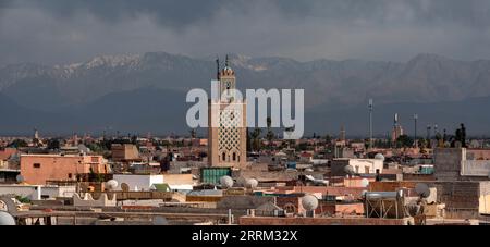 Malerischer Blick auf die Medina von Marrakesch und das Atlasgebirge im Hintergrund bei stürmischem Wetter, Marokko Stockfoto
