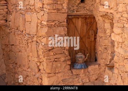 Eine alte Teedose vor einem antiken Fensterladen eines Berberhauses in Marokko Stockfoto