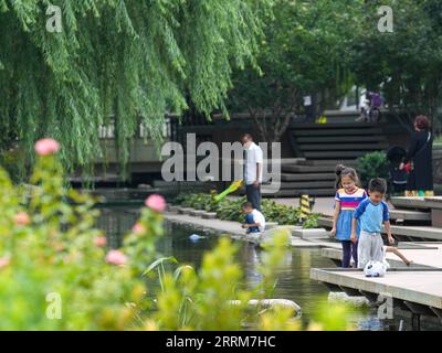 221005 -- PEKING, 5. Oktober 2022 -- Menschen spielen am 29. August 2022 im Dongcheng-Abschnitt des Yuhe-Flusses in Peking, der Hauptstadt Chinas. Die chinesischen Behörden haben geplant, die Beijing Central Axis als Chinas Projekt zur Anwendung des Weltkulturerbes 2024 zu empfehlen, so die National Cultural Heritage Administration. Die Pekinger Zentralachse ist 7,8 Kilometer lang, beginnend vom Yongding-Tor im Süden der Stadt bis zum Trommelturm und Glockenturm im Norden. Die meisten der großen Gebäude der Altstadt Pekings befinden sich entlang dieser Achse. Die Mittelachse ist das Rückgrat von Stockfoto