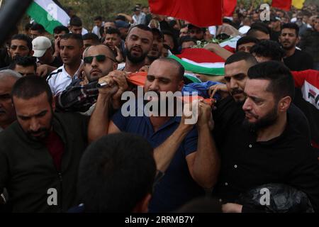 221013 -- HEBRON, 13. Oktober 2022 -- Trauernde tragen die Leiche von Osama Adawi, der von einem israelischen Soldaten während seiner Beerdigung im Westjordanland Hebron am 13. Oktober 2022 getötet wurde. Ein Palästinenser wurde getötet und drei weitere verletzt am Mittwoch während der Zusammenstöße mit den israelischen Soldaten im Al-Aroub Flüchtlingscamp nördlich der Stadt Hebron im südlichen Westjordanland, sagten palästinensische Gesundheitsbehörden und Augenzeugen. Das palästinensische Gesundheitsministerium sagte in einer Erklärung, dass Osama Adawi, 18, getötet wurde, nachdem er von einem israelischen Soldaten erschossen wurde, während die Zusammenstöße am Nachmittag ausbrachen, und fügte drei weitere hinzu Stockfoto