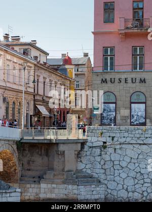 Sarajevo Museum 1878 – 1918 mit einem Teil der lateinischen Brücke am Ufer des Flusses Miljacka Sarajevo, Bosnien und Herzegowina, 8. September 2023 Stockfoto