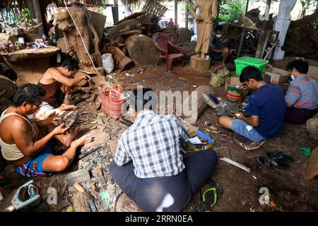 221124 -- YANGON, 24. November 2022 -- Holzschnitzer arbeiten an Artefakten in einem Workshop in Yangon, Myanmar, 22. November 2022. Die Bildhauer aus Myanmar's Darpein, bekannt als Zentrum der Holzbildhauerei des Landes, wurden gezwungen, ihre Geschäfte in andere Teile Myanmars zu verlagern, weil es an Rohstoffen mangelte. Die kleine Stadt, die 50 Kilometer nordöstlich der Innenstadt von Yangon liegt, ist bekannt als Darpein Holzskulpturendorf und beherbergt mehr als 1.000 Holzschnitzer. ZU DIESEM Feature: Was steckt hinter dem Exodus von Bildhauern aus Myanmars Holzwerkerdorf Foto von /Xinhua MYANMAR-YANGON-WOOD C. Stockfoto