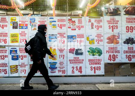 221224 -- NEW YORK, 24. Dezember 2022 -- Ein Fußgängerspaziergang vorbei an einem Supermarkt-Fenster mit Anzeigen in Queens, New York, USA am 23. Dezember 2022. Der PCE-Preisindex für Konsumausgaben in den USA stieg im November im Vergleich zum Monat um 0,1 Prozent, was weniger als 0,2 Prozent der Markterwartungen und 0,4 Prozent im Vormonat entspricht, laut Daten des US-Handelsministeriums am Freitagmorgen. Foto: Ziyu Julian Zhu/Xinhua US-NEW YORK-INFLATION-PCE PREISINDEX ZiyuxZhu PUBLICATIONxNOTxINxCHN Stockfoto