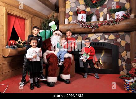 221224 -- BEIRUT, 24. Dez. 2022 -- Kinder und ein Mann im Weihnachtsmann-Kostüm posieren für Fotos auf einem Weihnachtsmarkt in Beirut, Libanon, am 18. Dez. 2022. LIBANON-BEIRUT-WEIHNACHTSMARKT LiuxZongya PUBLICATIONxNOTxINxCHN Stockfoto
