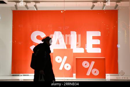 221231 -- BERLIN, 31. Dezember 2022 -- Eine Frau geht an einem Schaufenster mit Rabattschildern in Berlin vorbei, 30. Dezember 2022. DEUTSCHLAND-BERLIN-ALLTAG RenxPengfei PUBLICATIONxNOTxINxCHN Stockfoto