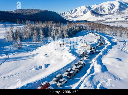 230113 -- ALTAY, 13. Januar 2023 -- dieses Luftbild zeigt Autos, die in das Skigebiet HEMU in der Präfektur Altay, der Autonomen Region Xinjiang Uygur im Nordwesten Chinas, einfahren, 12. Januar 2023. Die Präfektur Altay ist bekannt für ihre lange Wintersaison, die bis zu acht Monate im Jahr dauern kann. Es zieht Skifahrer weltweit mit seiner riesigen Fläche an natürlichem Pulverschnee an. Die Region hat sich in den letzten Jahren zum Ziel gesetzt, den Wintertourismus anzukurbeln und Besucher mit Skifahren, Eisfischen und anderen Winteraktivitäten zu begeistern. Zwischen dem 2022. Dezember und dem 11. Januar 2023 wurden dort rund 1,02 Millionen Touristen aufgenommen. CHINA-XINJIANG-ALTAY-WINTER Stockfoto