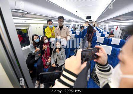 230115 -- SHENZHEN, 15. Januar 2023 -- Passagiere posieren für Fotos an Bord des Zuges G5607 nach Hongkong am Shenzhen North Railway Station in Shenzhen, Provinz Guangdong in Südchina, 15. Januar 2023. Nach fast dreijähriger Dienstaussetzung aufgrund der COVID-19-Pandemie nahm der Hongkong-Abschnitt der Guangzhou-Shenzhen-Hong Kong Express Rail Link am Sonntag den Betrieb wieder auf. im Durchschnitt verkehren täglich 38,5 Schnellzugpaare von den Bahnhöfen Guangzhou und Shenzhen bis zur Hong Kong West Kowloon Station. CHINA-GUANGZHOU-SHENZHEN-HONG KONG-EX Stockfoto