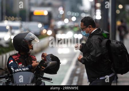 230201 -- JAKARTA, 1. Februar 2023 -- Ein Mann, der eine Fahrt braucht, spricht mit einem Motortaxi-Fahrer auf dem Gehweg der Thamrin Street in Jakarta, Indonesien, 1. Februar 2023. Indonesien verzeichnete im Januar eine Inflation von 5,28 Prozent gegenüber dem Vorjahr, die niedrigste seit August 2022, aber sie übertraf immer noch das Ziel der Zentralbank, so Statistics Indonesia BPS am Mittwoch. INDONESIEN-JAKARTA-INFLATIONS-VerixSanovri PUBLICATIONxNOTxINxCHN Stockfoto