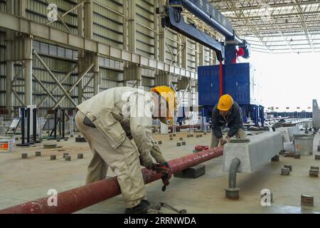 230131 -- ZHUHAI, 31. Januar 2023 -- Mitarbeiter legen Pipelines vor dem Gießen von Beton in die Tauchröhre E23 des Shenzhen-Zhongshan Highway Unterwassertunnels in einer Tauchröhrenfabrik der CCCC Fourth Harbour Engineering Co., Ltd. Auf Niutou Island, Zhuhai, Provinz Guangdong, 31. Januar 2023. Die Vorfertigung der E23, der letzten nicht standardmäßigen Tauchröhre, einschließlich der Endverbindung eines Unterwassertunnels, eines Abschnitts der Autobahn zwischen Shenzhen und Zhongshan in Guangdong, wurde am Dienstag abgeschlossen. Nach dem Gießen von Beton wiegt das 164 Meter lange Stahlrohr abo Stockfoto