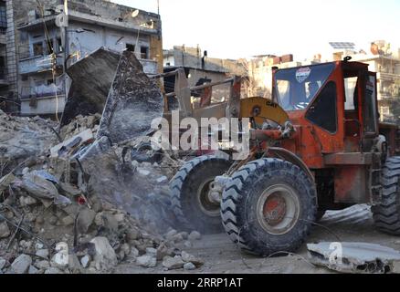 230210 -- ALEPPO, 10. Februar 2023 -- Ein Mann fährt einen Bulldozer, um die Trümmer zwischen eingestürzten Gebäuden in Aleppo, Syrien, zu räumen, 9. Februar 2023. Die Zahl der Todesopfer von den verheerenden Erdbeben am Montag in T¹rkiye und Syrien hat 21.000, laut neuesten Daten von Behörden und Rettungskräften, übertroffen. In Syrien wurden 1.678 Menschen in von der Regierung kontrollierten Gebieten getötet, und die Zahl der Todesopfer in der von der Opposition kontrollierten Region lag laut Medienberichten bei 2.190. STR/Xinhua SYRIA-EARTHQUAKE-RESCUE Stringer PUBLICATIONxNOTxINxCHN Stockfoto