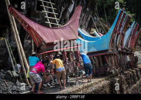 Nord-Toraja, Indonesien. September 2023. Familienmitglieder tragen den Saringgan (Sarg) von Verwandten während eines traditionellen Rituals namens „Manene“ auf dem Lokomata-Steinfriedhof. Das Ritual findet alle drei Jahre statt, wenn sich Familienmitglieder versammeln, um die Gräber zu reinigen und die Kleidung ihrer verstorbenen Verwandten zu ändern, um ihre Geister zu ehren. Quelle: SOPA Images Limited/Alamy Live News Stockfoto