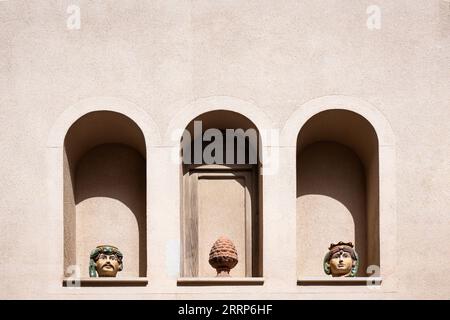 Drei bogenförmige Wandnischen in einer Gebäudewand mit sizilianischer Keramik Stockfoto