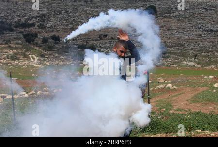 230224 -- BEIT DAJAN, 24. Februar 2023 -- ein palästinensischer Demonstrant nutzt eine Schleuder, um einen Tränengaskanister zurückzuwerfen, der von einem israelischen Soldaten während der Zusammenstöße nach einem Protest gegen die Expansion jüdischer Siedlungen im Westjorddorf Beit Dajan östlich von Nablus am 24. Februar 2023 abgefeuert wurde. Die Frage jüdischer Siedlungen im Westjordanland und in Ostjerusalem ist seit langem eine wichtige Quelle von Streitigkeiten zwischen Israelis und Palästinensern. Foto von /Xinhua MIDEAST-BEIT DAJAN-CLASHES NidalxEshtayeh PUBLICATIONxNOTxINxCHN Stockfoto