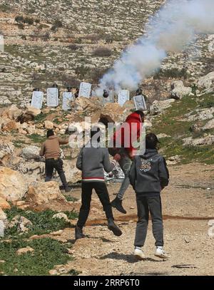 230224 -- BEIT DAJAN, 24. Februar 2023 -- ein israelischer Soldat feuert einen Tränengaskanister auf palästinensische Demonstranten während der Auseinandersetzungen nach einem Protest gegen die Expansion jüdischer Siedlungen im Westjordorfer Beit Dajan östlich von Nablus am 24. Februar 2023. Die Frage jüdischer Siedlungen im Westjordanland und in Ostjerusalem ist seit langem eine wichtige Quelle von Streitigkeiten zwischen Israelis und Palästinensern. Foto von /Xinhua MIDEAST-BEIT DAJAN-CLASHES NidalxEshtayeh PUBLICATIONxNOTxINxCHN Stockfoto