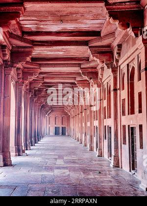 Ein langer Korridor aus rotem Sandstein befindet sich in der Moschee von Fatehpur Sikri in Rajasthan, Indien. Stockfoto