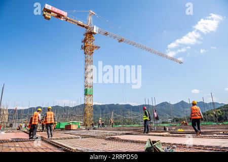 230314 -- CHONGQING, 14. März 2023 -- Arbeiter arbeiten auf einer Baustelle des Automobilelektronik-Industrieparks Chongqing Donggang in der südwestchinesischen Gemeinde Chongqing, 13. März 2023. Das Projekt wird den Wandel und die Modernisierung der Automobilindustrie in Chongqing beschleunigen. CHINA-CHONGQING-AUTOMOTIVE ELECTRONICS PARK CN TANGXYI PUBLICATIONXNOTXINXCHN Stockfoto