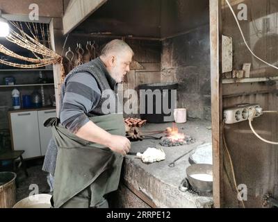 230316 -- ANKARA, 16. März 2023 -- Ein Kupferschmied verarbeitet Kupferprodukte in einer Werkstatt in Ankara, T¹rkiye, 14. März 2023. TRKIYE-ANKARA-KUPFER HANDWERKSKUNST LixZhenbei PUBLICATIONxNOTxINxCHN Stockfoto