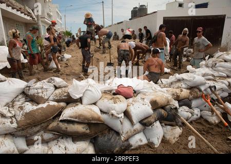 230317 -- LIMA, 17. März 2023 -- Menschen bauen eine temporäre Barriere, um Erdrutsche durch starken Regen in Punta Hermosa, Peru, zu verhindern, 16. März 2023. Der Zyklon Yaku hat in den letzten Tagen Regenströme in der nördlichen Region Perus ausgelöst. Foto von /Xinhua PERU-LIMA-CYCLONE YAKU-AFTERMATH MarianaxBazo PUBLICATIONxNOTxINxCHN Stockfoto