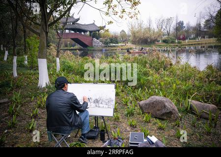 230321 -- HANGZHOU, 21. März 2023 -- Ein Mann skizziert am Sanyang Sumpfland in Wenzhou, ostchinesische Provinz Zhejiang, 16. März 2023. Die Provinz Zhejiang hat dem Wasserumweltmanagement oberste Priorität im ökologischen Bauwesen eingeräumt, indem sie die Wasserqualität von Hunderten von Seen und Flüssen erhöht und städtische Aktivitätsgebiete am Wasser errichtet hat. CHINA-ZHEJIANG-WASSER-UMWELT-MANAGEMENT CN JIANGXHAN PUBLICATIONXNOTXINXCHN Stockfoto