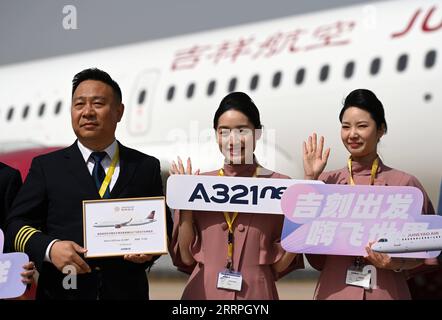 230324 -- TIANJIN, 24. März 2023 -- Besatzungsmitglieder der Juneyao Air aus Shanghai, die an der Lieferzeremonie des ersten in China montierten A321neo-Flugzeugs teilnehmen, posieren für ein Gruppenfoto vor dem Flugzeug im nordchinesischen Tianjin am 24. März 2023. Der europäische Flugzeughersteller Airbus begann am Freitag mit der Auslieferung von A321neo-Flugzeugen, die in seinem Werk Final Assembly Line Asia FALA im nordchinesischen Tianjin montiert wurden. Das erste in China montierte Flugzeug A321neo wurde an Juneyao Air in Shanghai geliefert. Airbus begann im November 2022 mit der Produktion von Flugzeugen der A321-Serie im Werk FALA. FALA jetzt Stockfoto