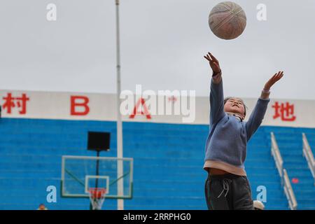 230325 -- TAIJIANG, 25. März 2023 -- Ein Kind spielt Basketball in Taipan Village, Taijiang County, Südwestchinesische Provinz Guizhou, 25. März 2023. Village Basketball Association oder Village BA ist ein Grassroot-Basketballturnier, das in Taipan Village ausgetragen wird. Diese Veranstaltung, die von Anwohnern organisiert wird, hat im Laufe der Jahre an Popularität gewonnen und zieht eine große Menge an Zuschauern und Teilnehmern gleichermaßen an. Das Turnier zeigt die Leidenschaft und das Können von Basketballspielern aus ländlichen Gegenden, während sie auf dem Spielfeld gegeneinander antreten und ihre Teamarbeit demonstrieren. SPCHINA-GUIZHOU-TAIJIANG-BASKETBALL-LIFESTYLE CN OUXD Stockfoto