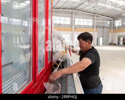 230325 -- TAXKORGAN, 25. März 2023 -- Duri Jarman überprüft einen Kühlschrank, den er für seinen Laden im Aimin-Dorf des autonomen Bezirks Taxkorgan Tadschik im Nordwesten Chinas Xinjiang Uygur Autonomous Region gekauft hat, 24. Juni 2020. Das Leben des Hirten Duri Jarman ist eng mit zwei Orten verbunden: Dem Dorf Ak toga Langar, das tief in den Bergen des autonomen Bezirks Taxkorgan Tadschik liegt, und dem Dorf Aimin, das sich in der Nähe des Verwaltungssitzes befindet. Duri, heute 52 Jahre alt, lebte 47 Jahre im Dorf Ak toga Langar. Im Winter 2018 profitierte seine Familie von der Umsiedlungspolitik zur Armutsbekämpfung Stockfoto