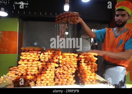 230328 -- BOUFARIK ALGERIEN, 28. März 2023 -- Ein Mann macht während des Ramadan in Boufarik, Algerien, am 28. März 2023 Ein traditionelles Dessert namens Zalabia. ALGERIEN-BOUFARIK-RAMADAN-DESSERT WuxTianyu PUBLICATIONxNOTxINxCHN Stockfoto