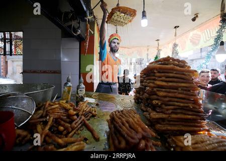 230328 -- BOUFARIK ALGERIEN, 28. März 2023 -- Ein Mann macht während des Ramadan in Boufarik, Algerien, am 28. März 2023 Ein traditionelles Dessert namens Zalabia. ALGERIEN-BOUFARIK-RAMADAN-DESSERT WuxTianyu PUBLICATIONxNOTxINxCHN Stockfoto