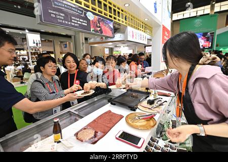 230412 -- HAIKOU, 12. April 2023 -- Besucher probieren Steaks auf der dritten China International Consumer Products Expo CICPE in Haikou, Hauptstadt der südchinesischen Provinz Hainan, 12. April 2023. Verschiedene Lebensmittel und Getränke aus der ganzen Welt werden während der expo vom 10. Bis 15. April vorgestellt. CHINA-HAINAN-CICPE-FOOD CN LixXin PUBLICATIONxNOTxINxCHN Stockfoto