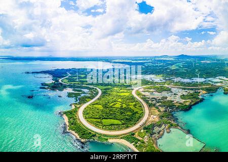 230412 -- HAIKOU, 12. April 2023 -- dieses Luftbild, das am 6. Oktober 2022 aufgenommen wurde, zeigt einen Abschnitt der touristischen Autobahn um die Insel in Danzhou, Südchinas Provinz Hainan. Xinhua Schlagzeilen: Fünf Jahre später beschleunigt China den Bau des Freihandelshafens PuxXiaoxu PUBLICATIONxNOTxINxCHN in Hainan Stockfoto