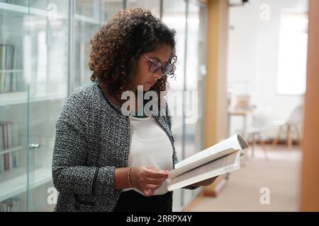 230415 -- PEKING, 15. April 2023 -- Rafaela R liest ein Buch in einer Bibliothek der Peking Universität in Peking, Hauptstadt von China, 31. März 2023. Maria Eduarda Variani, Rafaela Viana dos Santos, Manuela Boiteux Pestana und Marco Andre Rocha Germano sind brasilianische Studenten, die im Master of China Studies an der Yenching Academy der Peking University in China studieren. Die vier interessieren sich seit ihrer Jugend für die chinesische Kultur. Nach der Ankunft in Peking sind sie beeindruckt von dem tiefgreifenden kulturellen Erbe der chinesischen Hauptstadt, den praktischen öffentlichen Dienstleistungen und der fabelhaften Stadt Stockfoto