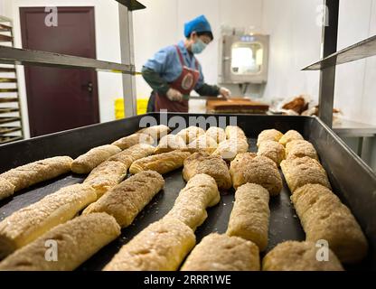 230426 -- TACHENG, 26. April 2023 -- ein Mitarbeiter arbeitet in der Werkstatt des Jiangqu Lebensmittelunternehmens in Tacheng, Nordwestchinas autonome Region Xinjiang Uygur, 1. April 2023. Die kleine Stadt Tacheng liegt an der Grenze von China und Kasachstan und beherbergt Menschen von 25 ethnischen Gruppen. Wang Huipeng und seine Frau eröffneten hier 2016 eine Bäckerei. Jetzt hat sich die Bäckerei zu einer kleinen Lebensmittelfabrik namens Jiangqu mit Mitarbeitern aus 9 verschiedenen ethnischen Gruppen entwickelt. Viele ihrer Produkte sind lokale Favoriten, unter denen ihr charakteristisches Tacheng-Käsebrot immer mehr Aufmerksamkeit erregt und hat Stockfoto