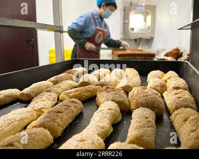 230426 -- TACHENG, 26. April 2023 -- ein Mitarbeiter arbeitet in der Werkstatt des Jiangqu Lebensmittelunternehmens in Tacheng, Nordwestchinas autonome Region Xinjiang Uygur, 1. April 2023. Die kleine Stadt Tacheng liegt an der Grenze von China und Kasachstan und beherbergt Menschen von 25 ethnischen Gruppen. Wang Huipeng und seine Frau eröffneten hier 2016 eine Bäckerei. Jetzt hat sich die Bäckerei zu einer kleinen Lebensmittelfabrik namens Jiangqu mit Mitarbeitern aus 9 verschiedenen ethnischen Gruppen entwickelt. Viele ihrer Produkte sind lokale Favoriten, unter denen ihr charakteristisches Tacheng-Käsebrot immer mehr Aufmerksamkeit erregt und hat Stockfoto