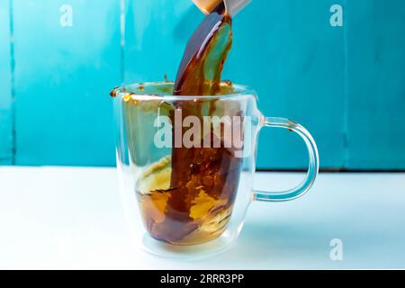 Kaffeeauslauf in einem Doppelglasbecher, Bewegungsunschärfe und Weichzeichner aus nächster Nähe Stockfoto