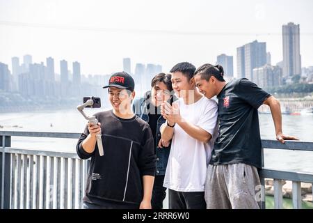 230510 -- PEKING, 10. Mai 2023 -- Wen Shunyao 1st R macht am 14. März 2023 kurze Videos mit Mitgliedern des Yuefei Parkour Club rund um die Dongshuimen-Brücke in der südwestchinesischen Gemeinde Chongqing. Chongqing, eine Stadt, die auf Bergen erbaut wurde, bietet eine Stadtlandschaft aus Höhen und Tiefen und verstreuten Gebäuden. Die Straße wird oft auf dem Dach gebaut, und die Stadtbahn verläuft durch die Gebäude in der südwestlichen chinesischen Metropole. Mit den natürlichen Vorteilen des Parkour, auch bekannt als Freilauf, bietet Chongqing den Praktizierenden des Parkour einen Spielplatz, auf dem sie Hindernisse überwinden Stockfoto