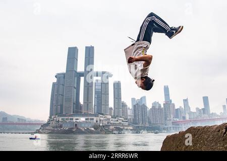 230510 -- PEKING, 10. Mai 2023 -- Wen Shunyao zeigt am 21. April 2023 Parkourbewegungen rund um den Chaotianmen-Kai in der südwestchinesischen Gemeinde Chongqing. Chongqing, eine Stadt, die auf Bergen erbaut wurde, bietet eine Stadtlandschaft aus Höhen und Tiefen und verstreuten Gebäuden. Die Straße wird oft auf dem Dach gebaut, und die Stadtbahn verläuft durch die Gebäude in der südwestlichen chinesischen Metropole. Mit den natürlichen Vorteilen des Parkour, auch bekannt als Free-Running, bietet Chongqing den Praktizierenden des Parkour einen Spielplatz, auf dem sie Hindernisse in der städtischen Landschaft überwinden können, ohne Hilfe zu leisten Stockfoto