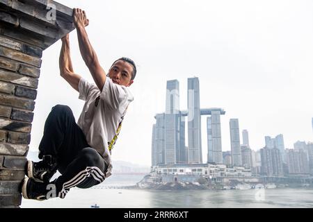 230510 -- PEKING, 10. Mai 2023 -- Wen Shunyao zeigt am 21. April 2023 Parkourbewegungen rund um den Chaotianmen-Kai in der südwestchinesischen Gemeinde Chongqing. Chongqing, eine Stadt, die auf Bergen erbaut wurde, bietet eine Stadtlandschaft aus Höhen und Tiefen und verstreuten Gebäuden. Die Straße wird oft auf dem Dach gebaut, und die Stadtbahn verläuft durch die Gebäude in der südwestlichen chinesischen Metropole. Mit den natürlichen Vorteilen des Parkour, auch bekannt als Free-Running, bietet Chongqing den Praktizierenden des Parkour einen Spielplatz, auf dem sie Hindernisse in der städtischen Landschaft überwinden können, ohne Hilfe zu leisten Stockfoto