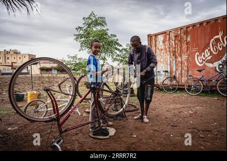 230512 -- ASMARA, 12. Mai 2023 -- Kinder reparieren Fahrräder in Asmara, Eritrea, 8. Mai 2023. Radfahren wurde in das Leben der Einheimischen integriert und wurde zu einem wichtigen Sport in Eritrea. ERITREA-ASMARA-BIKE-ALLTAG WangxGuansen PUBLICATIONxNOTxINxCHN Stockfoto