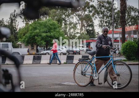 230512 -- ASMARA, 12. Mai 2023 -- ein älterer schiebt sein Fahrrad und geht in Asmara, Eritrea, 8. Mai 2023 über die Straße. Radfahren wurde in das Leben der Einheimischen integriert und wurde zu einem wichtigen Sport in Eritrea. ERITREA-ASMARA-BIKE-ALLTAG WangxGuansen PUBLICATIONxNOTxINxCHN Stockfoto