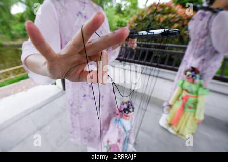 230519 -- NANJING, 19. Mai 2023 -- Sun Jing und Shi Jinfang Proben das Marionettenspiel der Kunqu Opera in einem Park in Qidu Stadt, Wujiang Bezirk der Stadt Suzhou, ostchinesische Provinz Jiangsu, 18. April 2023. Kunqu, mit einer hundertjährigen Geschichte, wurde 2001 von der UNESCO der Organisation der Vereinten Nationen für Erziehung, Wissenschaft und Kultur als immaterielles Kulturerbe aufgeführt. In der Stadt Qidu in Suzhou gibt es eine einzigartige Form der Kunqu-Oper namens Kunqu Puppet, in der Schauspieler mit Marionetten auf der Bühne auftreten. Um die traditionelle Kunqu-Puppe Sun Jing, Shi Jinf, zu erben Stockfoto