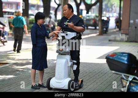 230520 -- XIANGTAN, 20. Mai 2023 -- Fu Ting L spricht mit einem behinderten Mann über seine Rehabilitation und Erleichterung von Ausrüstung im Bezirk Yuhu von Xiangtan, Provinz Hunan in Zentralchina, 18. Mai 2023. Fu Ting verlor ihren rechten Arm bei einem Autounfall, als sie 3 Jahre alt war. Im Alter von 13 Jahren begann sie mit dem Schwimmtraining an einer Sportschule in Xiangtan. Während ihrer Zeit als Athletin nahm sie an den Paralympischen Spielen 2004 in Athen und anderen in- und ausländischen Veranstaltungen Teil und gewann 18 Goldmedaillen. Nach seiner Pensionierung im Jahr 2004 trat Fu Ting an die Universität ein, um Jura zu studieren und arbeitete nach seinem Abschluss als Rechtsanwalt Stockfoto