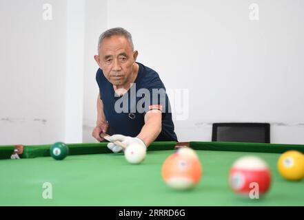 230524 -- SHIJIAZHUANG, 24. Mai 2023 -- Ein Bewohner spielt Billard in der Nanwenying-Gemeinde im Bezirk Rongdong des Xiong an New Area, nordchinesische Provinz Hebei, 23. Mai 2023. In den letzten Jahren hat die Gemeinde Nanwenying in Xiong an New Area, Provinz Hebei, das öffentliche Dienstleistungssystem der Gemeinde ständig verbessert. Eine Reihe von öffentlichen Serviceeinrichtungen auf Nachbarschaftsebene, wie die Kantine, der Gemeinschaftsversammlungsraum, die Rentenzentrale und die Komfortstation, wurden gebaut, um den Bewohnern zu dienen und einen 15-minütigen Wohndienstkreis für lebenswerte Gemeinden zu schaffen. CHINA-HEBEI-XI Stockfoto