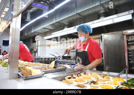 230524 -- SHIJIAZHUANG, 24. Mai 2023 -- Ein Mitarbeiter bereitet Eine Mahlzeit in einer Kantine der Gemeinde Nanwenying im Bezirk Rongdong des Xiong an New Area, Provinz Hebei in Nordchina, 23. Mai 2023. In den letzten Jahren hat die Gemeinde Nanwenying in Xiong an New Area, Provinz Hebei, das öffentliche Dienstleistungssystem der Gemeinde ständig verbessert. Eine Reihe von öffentlichen Serviceeinrichtungen auf Nachbarschaftsebene, wie die Kantine, der Gemeinschaftsversammlungsraum, die Rentenzentrale und die Komfortstation, wurden gebaut, um den Bewohnern zu dienen und einen 15-minütigen Wohndienstkreis für lebenswerte Gemeinden zu schaffen. Stockfoto