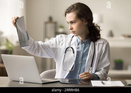 Ein seriöser junger Praktiker, der sich das Röntgenbild von Knochen anschaut Stockfoto