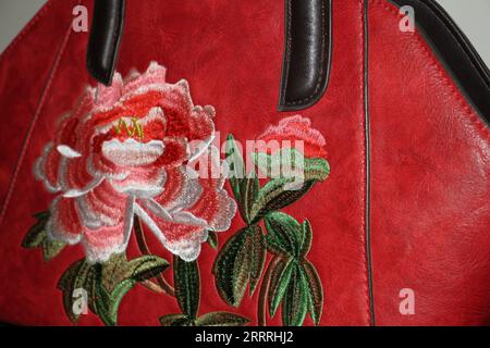 Eine rote Handtasche mit Motiv darauf. Stockfoto