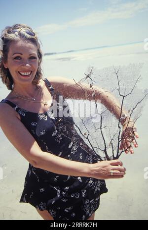 Ingrid Peters, deutsche Sängerin und Radiomoderatorin, mit Koralle bei einem Strandfotoshooting in der Dominikanischen Republik, 2000. Stockfoto