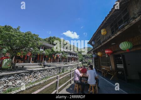 230612 -- HANGZHOU, 12. Juni 2023 -- Menschen trinken Tee entlang eines Baches im Dorf Budaikeng in Taizhou, ostchinesische Provinz Zhejiang, 30. Mai 2023. Im Juni 2003 startete Zhejiang das Green Rural Revival Program, das etwa 10.000 eingegliederte Dörfer sanieren und etwa 1.000 zentrale Dörfer in Beispiele von mäßigem Wohlstand in jeder Hinsicht verwandeln will. Dank des Programms wurde das Bild der Landschaft in der Provinz Zhejiang umfassend aufgewertet. Insgesamt wurden 2.170 Dörfer und über 3 Millionen schöne ländliche Innenhöfe gebaut. CHINA-ZHEJIANG-G Stockfoto