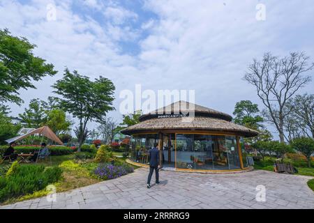 230612 -- HANGZHOU, 12. Juni 2023 -- Ein Café ist im Dorf Wupu in Huzhou, ostchinesische Provinz Zhejiang, 11. April 2023, abgebildet. Im Juni 2003 startete Zhejiang das Green Rural Revival Program, das etwa 10.000 eingegliederte Dörfer sanieren und etwa 1.000 zentrale Dörfer in Beispiele von mäßigem Wohlstand in jeder Hinsicht verwandeln will. Dank des Programms wurde das Bild der Landschaft in der Provinz Zhejiang umfassend aufgewertet. Insgesamt wurden 2.170 Dörfer und über 3 Millionen schöne ländliche Innenhöfe gebaut. CHINA-ZHEJIANG-GRÜNE RURA Stockfoto